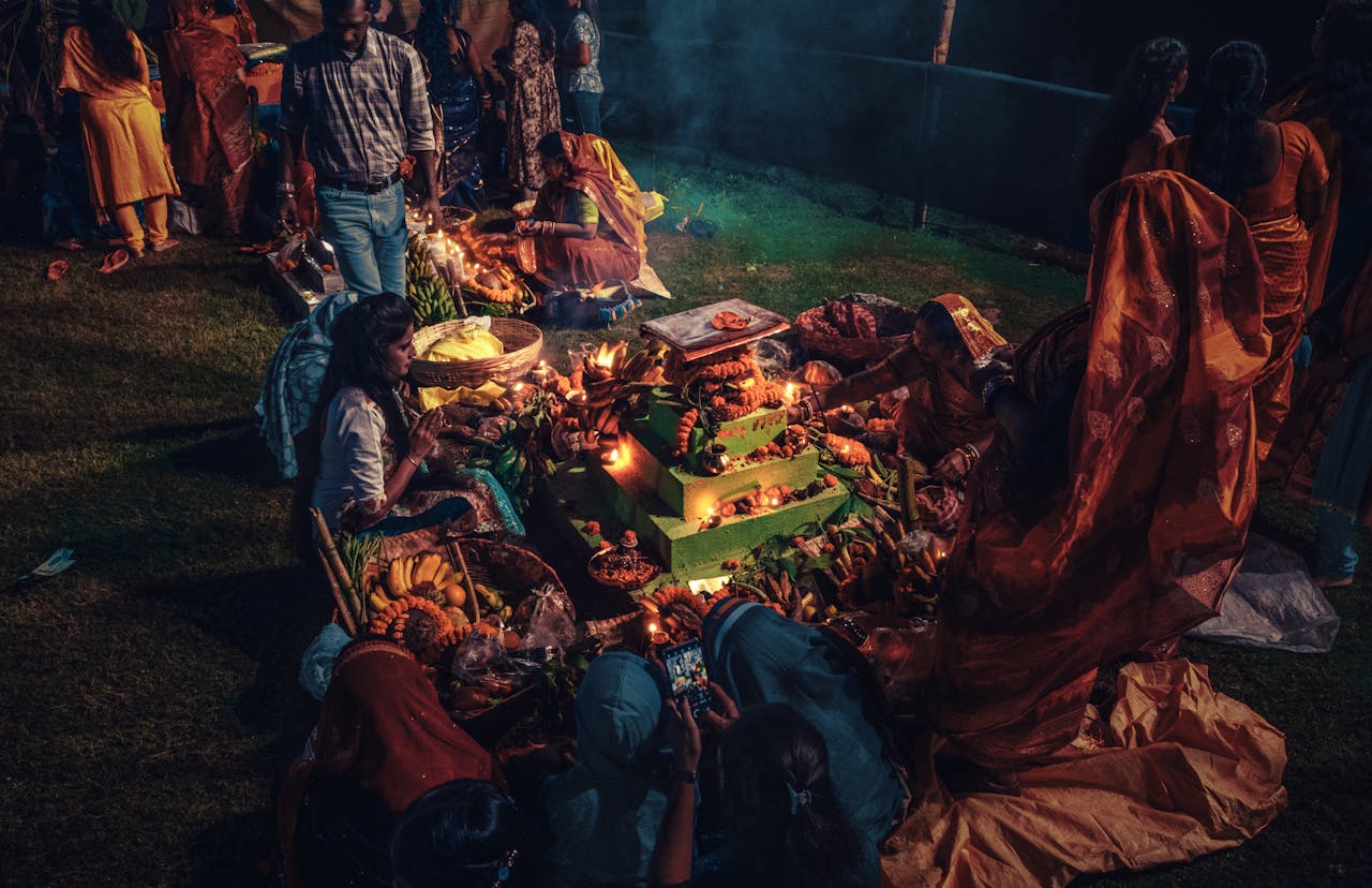 A culturally rich Hindu ritual ceremony with offerings and people gathered at night.